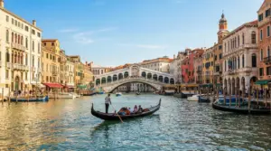 Ponte di Rialto sul Canal Grande a Venezia con gondola e palazzi storici